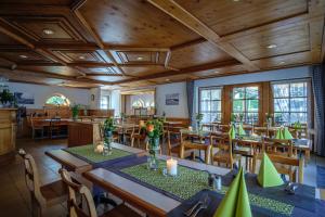 un ristorante con soffitti e tavoli in legno e sedie di Landgasthof Camping a Wagenhausen