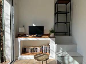 a living room with a tv and a book shelf at Clos Manila in La Seyne-sur-Mer