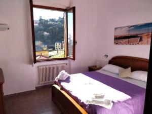 um quarto com uma cama e uma grande janela em ca augusto with seaview em Monterosso al Mare