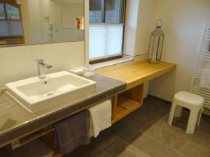La salle de bains est pourvue d'un lavabo et d'un miroir. dans l'établissement Holiday apartment Sonnenkopfblick with sauna, à Fischen im Allgäu