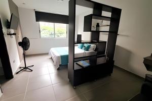 ein Schlafzimmer mit einem Bett und einem Spiegel in einem Zimmer in der Unterkunft 405 Moderno Aparta-Suite en Versalles Tipo Loft - Cali Tower Suites & Lofts in Cali
