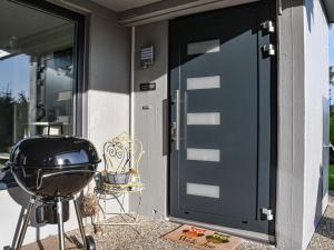 uma porta da frente de uma casa com um grelhador em Holiday apartment Owl's Nest em Tennenbronn