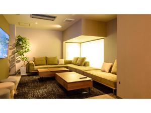 Hotel Three M - Vacation STAY 93394v في كوتشان: غرفة معيشة مع أريكة وطاولة