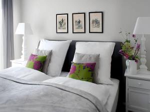 een slaapkamer met een bed met witte en groene kussens bij Appealing apartment in Westerstede in Westerstede