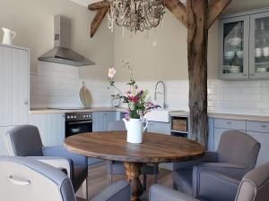een keuken met een tafel met stoelen en een boom bij Appealing apartment in Westerstede in Westerstede
