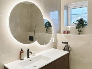 ein Bad mit einem Waschbecken und einem Spiegel in der Unterkunft Holiday home VÄSTERVIK III in Västervik