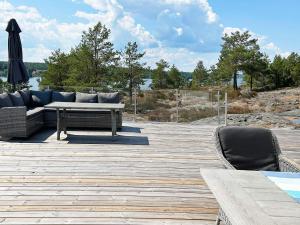 een patio met een bank, een tafel en een parasol bij Holiday home VÄSTERVIK III in Västervik