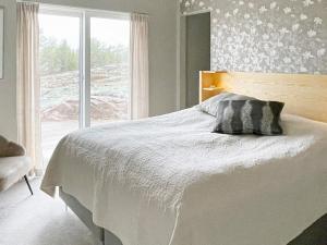 um quarto com uma cama branca e uma janela em Holiday home VÄSTERVIK III em Västervik