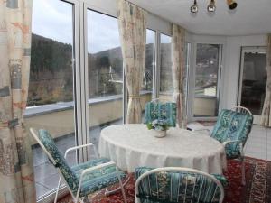 a room with a table and chairs and windows at Holiday apartment Schlossblick 2 in Zwingenberg
