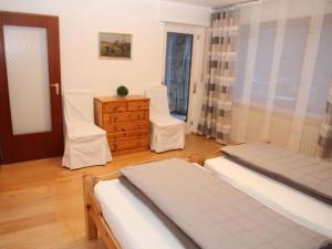 a bedroom with two beds and a dresser and a window at Holiday apartment Schlossblick 2 in Zwingenberg