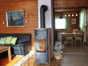sala de estar con chimenea, sofá y mesa en Appealing apartment in Grafenau en Haus im Wald