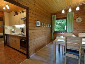 cocina con paredes de madera, mesa y comedor en Appealing apartment in Grafenau en Haus im Wald