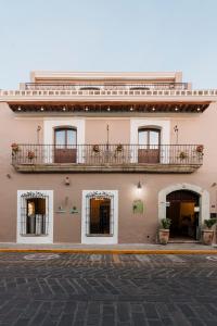 a building with two balconies on the side of it at Hotel Casa Antigua in Oaxaca City