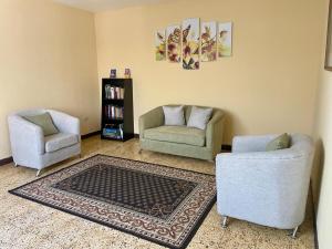 een woonkamer met 2 stoelen en een tapijt bij Casa Quetzal in Guatemala