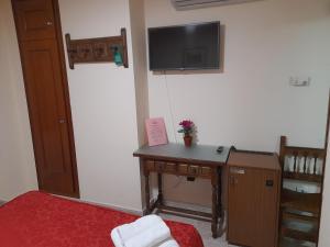a room with a desk and a tv on a wall at Hostal San Roque in Guadalajara