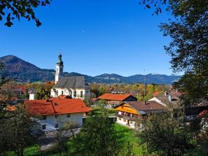 a small town with a church with a clock tower at Lovely apartment in Lenggries in Lenggries