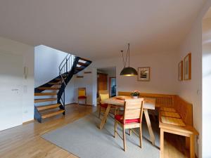 a dining room with a table and a staircase at Lovely apartment in Lenggries in Lenggries