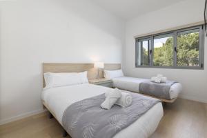 two beds in a room with two windows at ApartUP Turia River Park in Valencia