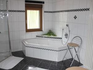 een badkamer met een bad, een douche en een stoel bij Apartment in Zwingenberg in Zwingenberg