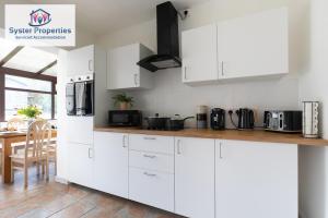 uma cozinha com armários brancos e uma bancada em Tetuan House - Syster Properties - Work -Family - Groups Leicester LE3 em Leicester