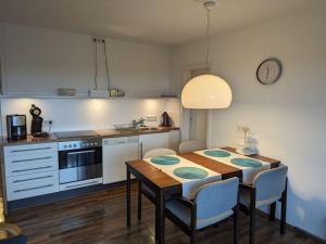 eine Küche mit einem Tisch und eine Küche mit einem Herd in der Unterkunft Apartment in Schotten-Betzenrod 