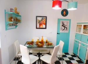 a dining room with a glass table and white chairs at 50's Carthago Rock Experiencias Carthago Tematizadas in Cartagena
