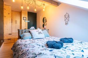 - une chambre avec un grand lit et des oreillers bleus dans l'établissement La Belle Vue : Duplex avec Terrasse,Jardin,Parking, à Annecy