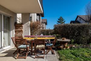une table et des chaises en bois assises sur une terrasse dans l'établissement La Belle Vue : Duplex avec Terrasse,Jardin,Parking, à Annecy