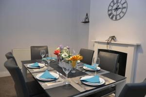 a dining room with a table with chairs and a fireplace at Salisbury - New 3br home, wifi, parking, sleeps 6, near Liverpool city centre in Birkenhead