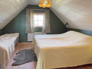 - une chambre mansardée avec 2 lits et une fenêtre dans l'établissement Holiday home LÖTTORP XIV, à Löttorp