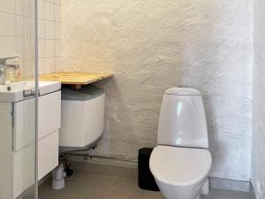 La salle de bains est pourvue de toilettes blanches et d'un lavabo. dans l'établissement Holiday home LÖTTORP XIV, à Löttorp