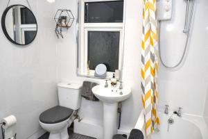 ein Badezimmer mit einem WC, einem Waschbecken und einem Spiegel in der Unterkunft Salisbury - New 3br home, wifi, parking, sleeps 6, near Liverpool city centre in Birkenhead