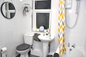 a bathroom with a toilet and a sink and a mirror at Salisbury - New 3br home, wifi, parking, sleeps 6, near Liverpool city centre in Birkenhead