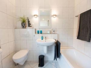 a white bathroom with a sink and a toilet at Holiday apartment Ross in Eslohe