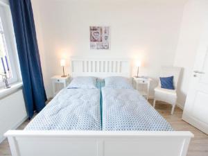 a white bed in a room with two chairs at Holiday apartment Ross in Eslohe