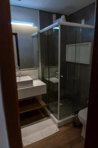 y baño con ducha acristalada y lavamanos. en Pousada Divino Morro en Fernando de Noronha