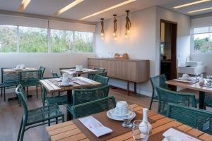 a dining room with wooden tables and green chairs at Pousada Divino Morro in Fernando de Noronha