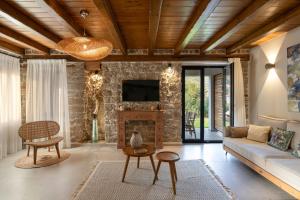 a living room with a couch and a fireplace at Lithos Villas Apollon in Sikia