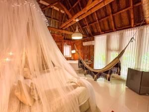 1 dormitorio con 1 cama con mosquitera en Ecohabs Bamboo Parque Tayrona - Dentro del PNN Tayrona, en El Zaino