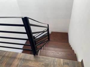 a staircase with a metal railing and wooden floors at Casa de descanso in León