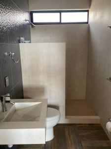 a bathroom with a toilet and a sink and a shower at Casa de descanso in León