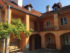 an old building with balconies and a tree at Apartments at the Golden Plough in Prague