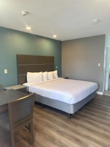 a bedroom with a bed and a desk and a table at Hotel Palmeras Chula Vista in Chula Vista