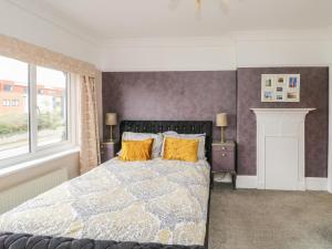 a bedroom with a bed with yellow pillows at Glendalough in Colwyn Bay