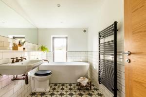 a bathroom with a tub and a sink and a toilet at Stunning 5 Bedroom New Build with Amazing Views! in Bath