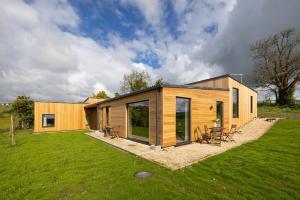 a small wooden house on a grass field at Stunning 5 Bedroom New Build with Amazing Views! in Bath