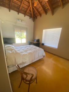 a bedroom with a bed and a chair and a window at Casa golf en las sierras de Cordoba in Cordoba