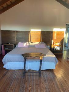 a bedroom with a large bed with a wooden floor at Casa golf en las sierras de Cordoba in Cordoba