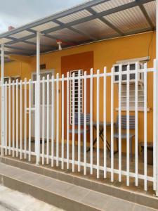 a white fence in front of a house at Transient House Orani in Orani