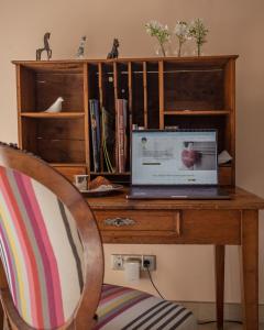 un ordinateur portable assis sur un bureau en bois avec une chaise dans l'établissement La Sorellerie, à Saint-Avertin